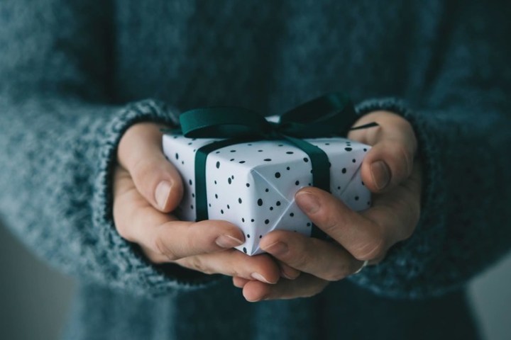 a hand holding a video game remote control